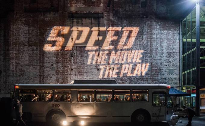Speed: The Movie, The Play logo projected on a wall