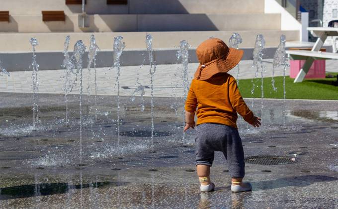 Small child playing with the Interactive Water Feature at Prahran Square