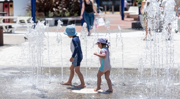 Two children playing with the interactive water feature at Prahran Square