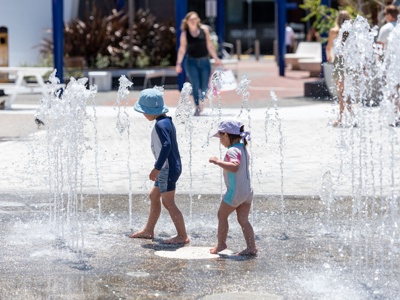 Two children playing with the interactive water feature at Prahran Square